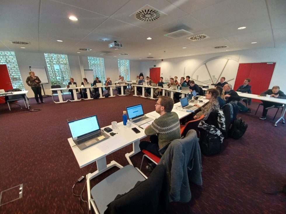 des adultes suivent un cours dans une salle de réunion