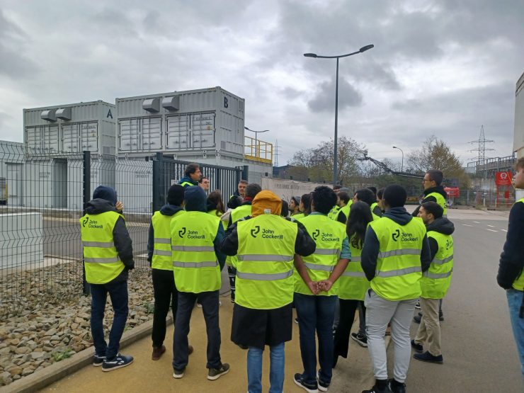 group of students in yellow visiting an industrial site