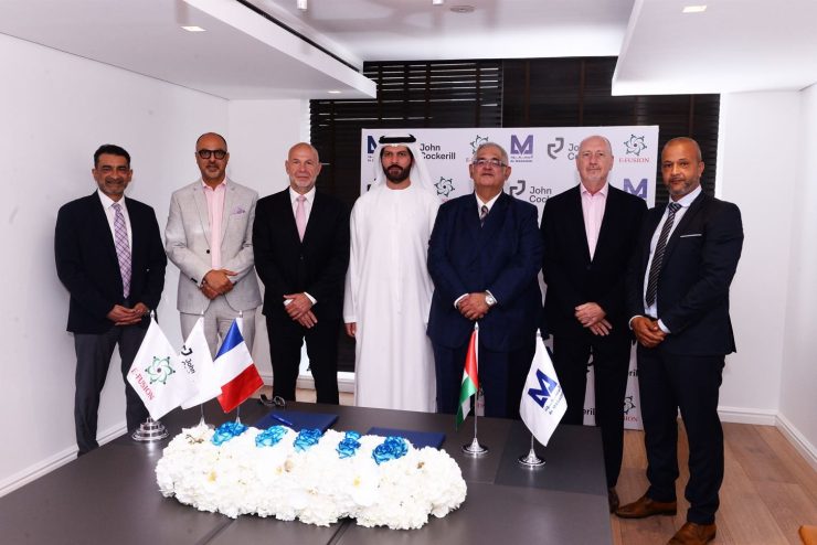 seven men posing in front of a table after the signature of a partnership in United Arab EMirates